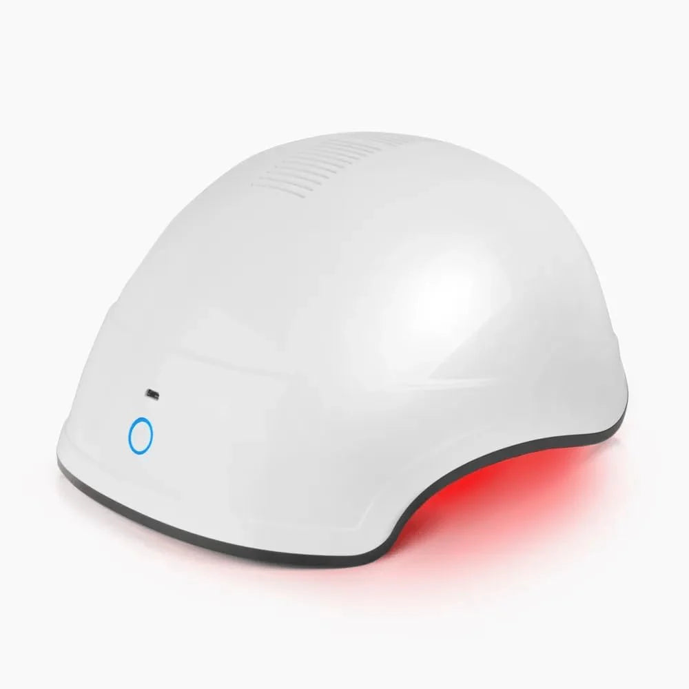 White rigid hair-growth helmet with a red glow beneath the shell.